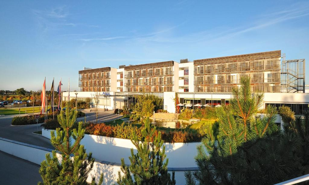 Hotelová budova Therme Laa se zahradou a vodní plochou